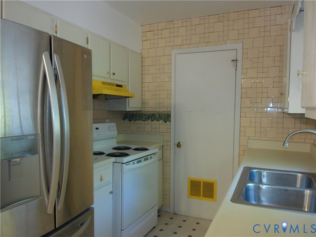 Kitchen featuring a stainless steel refrigerator, white electric range, white cabinetry, and a double basin stainless steel sink