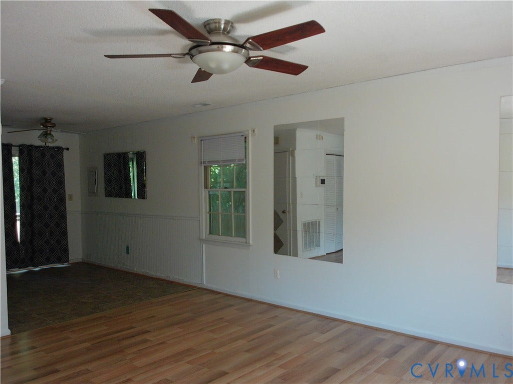 Wood-finish flooring with a ceiling fan and a window