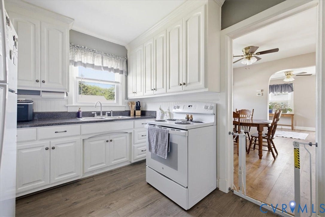 216 Conduit Road, Riverside Park, Colonial Heights, VA 23834 Kitchen featuring white cabinetry, dark countertops, a stainless steel sink with a gooseneck faucet, and wood-finish flooring