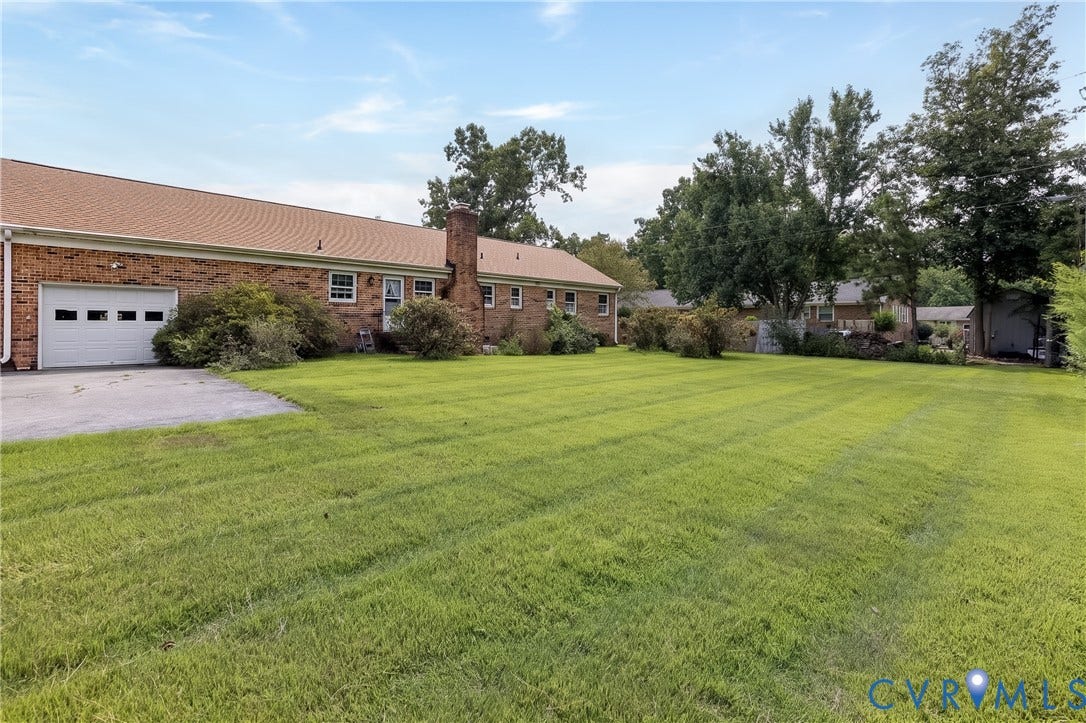 3640 Kiefer Road, Chester, VA 23831 Brick exterior residence featuring a single-door garage, concrete driveway, and expansive lawn