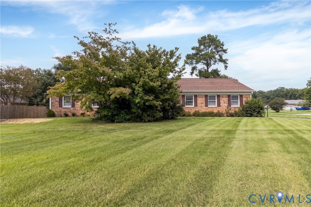 3640 Kiefer Road, Chester, VA 23831 Brick exterior with multiple windows featuring shutters, a gabled roof, and a mature tree