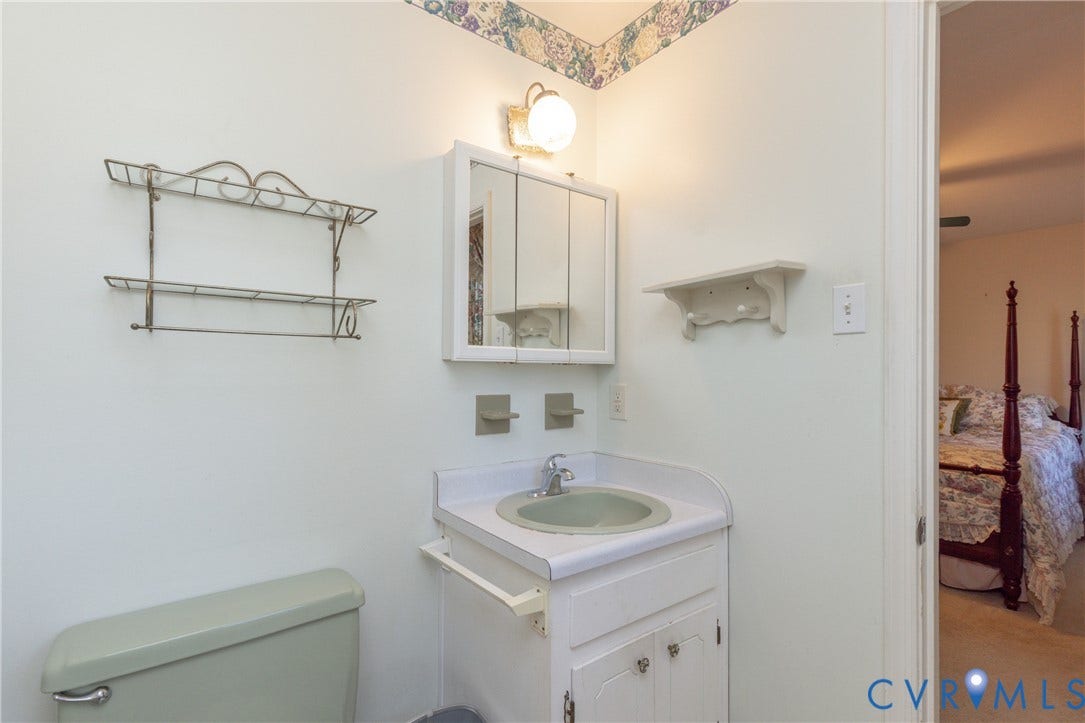 3640 Kiefer Road, Chester, VA 23831 Wall-mounted vanity with integrated sink, medicine cabinet with mirrored doors, and wall-mounted light fixture