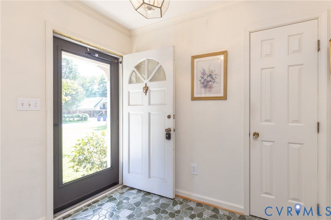 3640 Kiefer Road, Chester, VA 23831 Entryway featuring a white paneled door with an arched window, a full-lite storm door, patterned tile flooring, and a flush-mount ceiling light fixture
