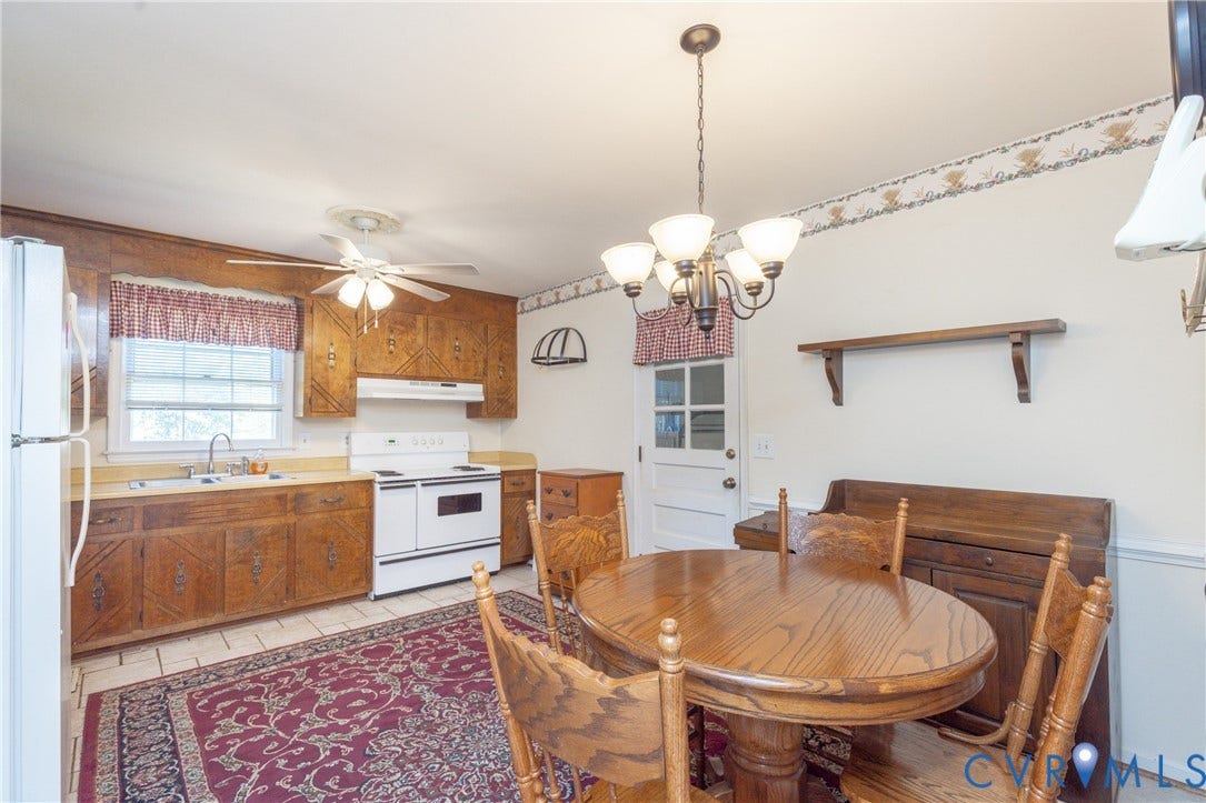 3640 Kiefer Road, Chester, VA 23831 Kitchen featuring wood-paneled upper cabinetry, tile flooring, white appliances, a ceiling fan, and a multi-light chandelier
