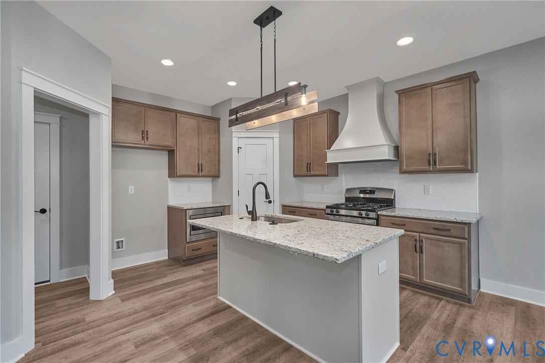11121 Somerset Hill Drive, Somerset Hills, Glen Allen, VA 23059 Kitchen featuring wood-finish flooring, recessed lighting, a central island with a stone countertop, stainless steel appliances, and wood cabinetry