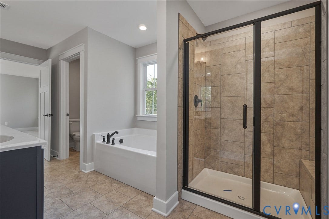 11121 Somerset Hill Drive, Somerset Hills, Glen Allen, VA 23059 Spacious bathroom featuring a built-in soaking tub, separate glass-enclosed shower with tile surround, dual sink vanity with a light-toned countertop, and tile flooring