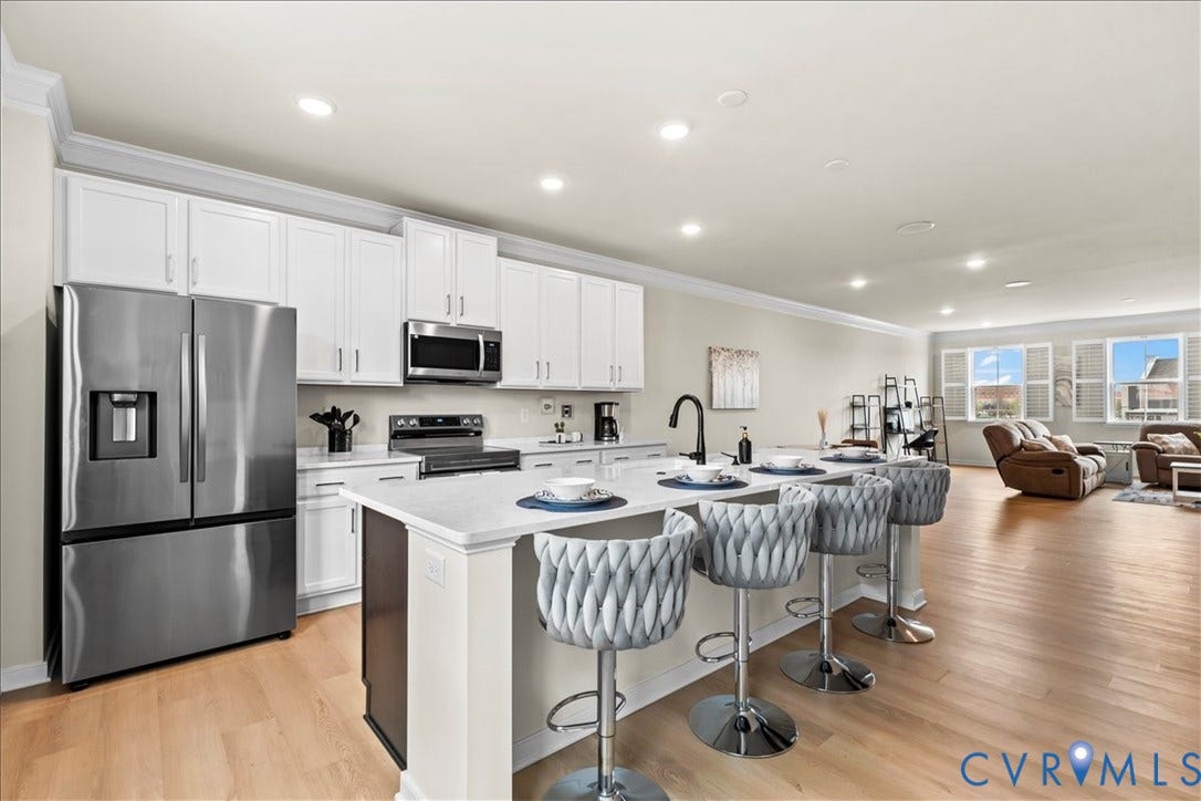 412 Quiet Breeze Alley, Chesterfield, VA 23113 Kitchen featuring white cabinetry, stainless steel appliances, an island with seating, and wood-finish flooring