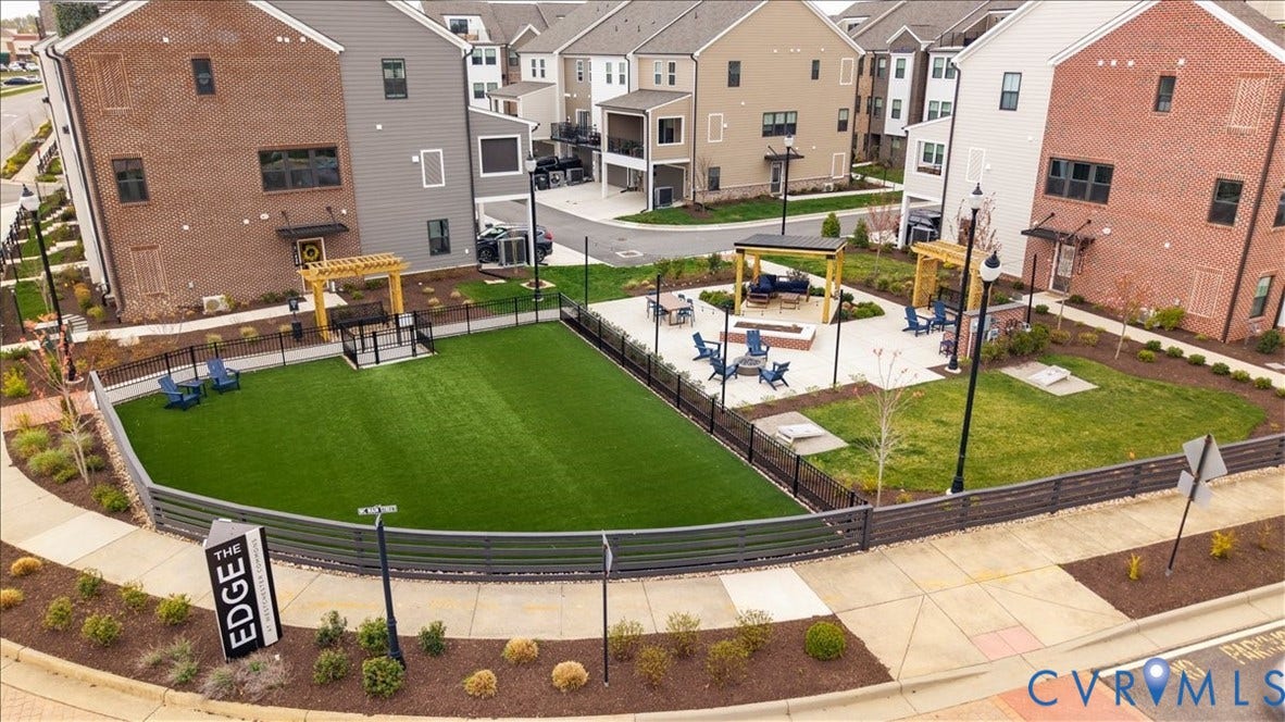 412 Quiet Breeze Alley, Chesterfield, VA 23113 Community green space featuring artificial turf, a paved patio with a fire pit, and two pergolas