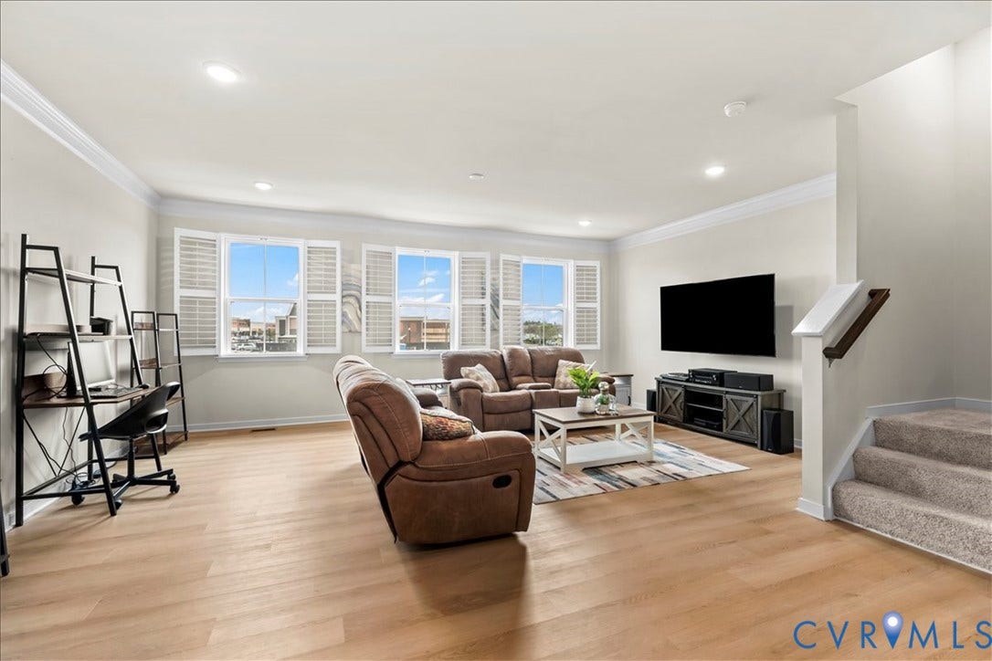 412 Quiet Breeze Alley, Chesterfield, VA 23113 Spacious living area featuring wood-finish flooring, recessed lighting, crown molding, a staircase with a wood handrail, and multiple windows with plantation shutters