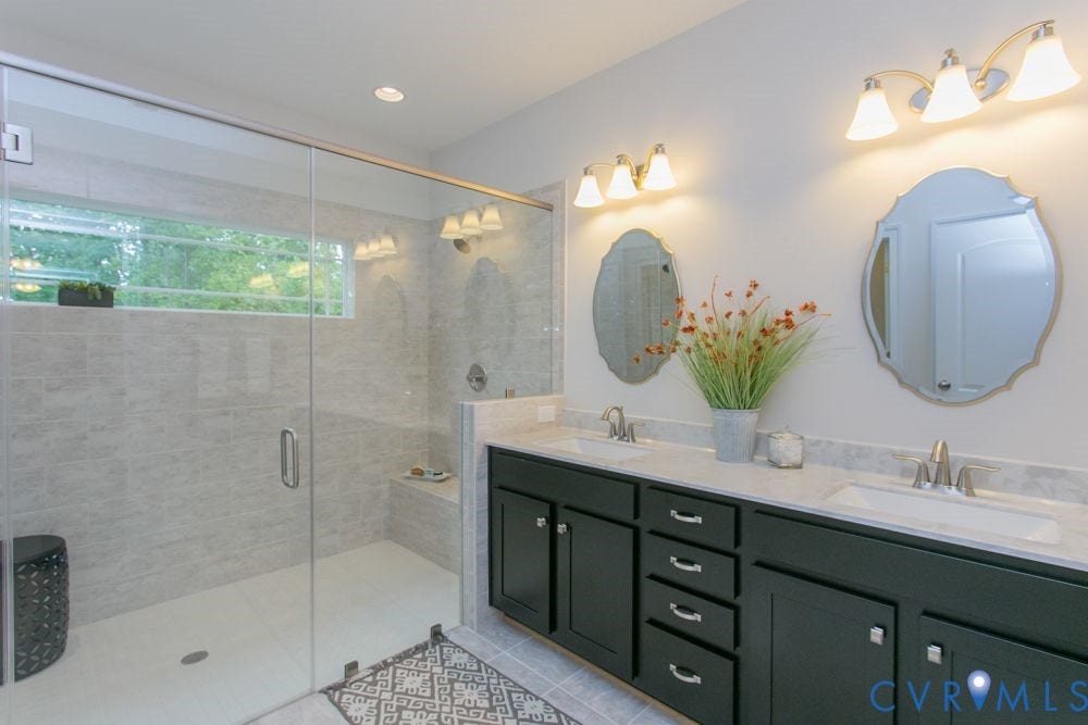 Dual vanity with dark cabinetry and light countertops