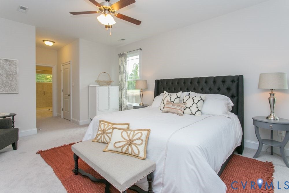 Recessed lighting, ceiling fan, tufted headboard, window with natural light, and plush carpeting