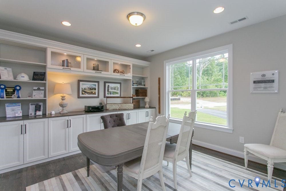 Built-in white cabinetry, recessed lighting, wood-finish flooring, large window, and light gray wall paint