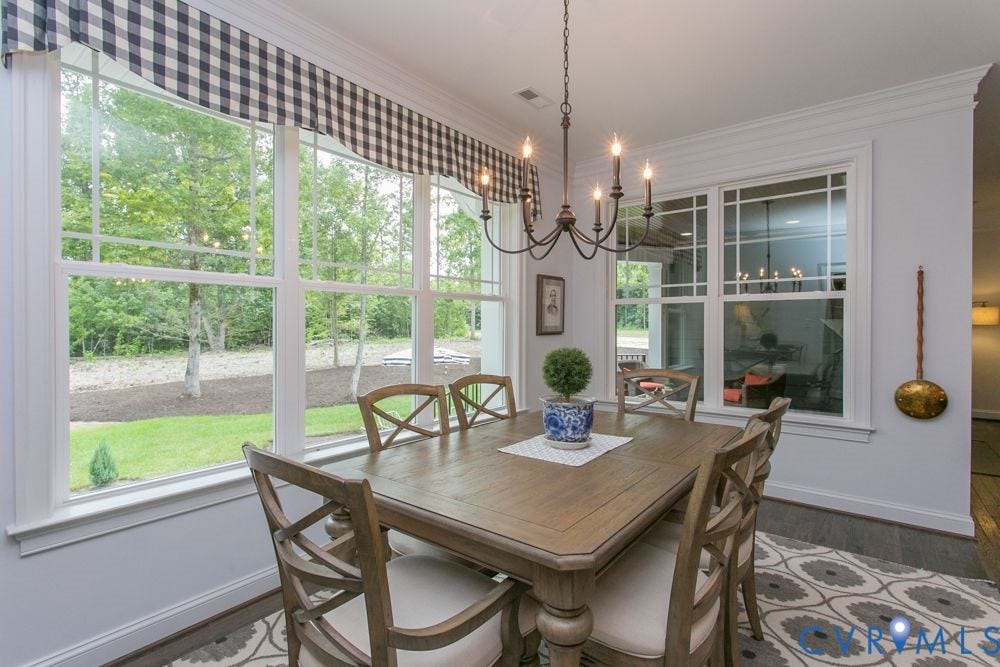 Recessed lighting, wood-finish flooring, white crown molding, large casement windows, and a multi-arm chandelier