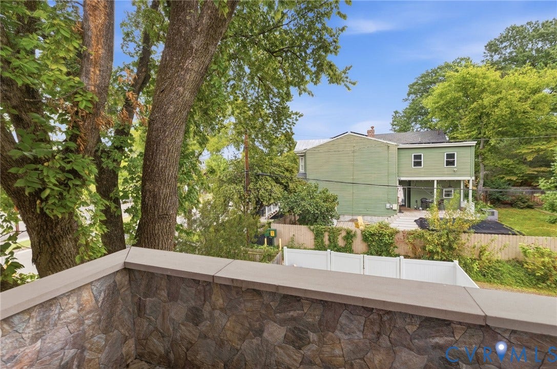 2002 Fairmount Avenue, Church Hill, Richmond, VA 23223 Stone veneer wall with capstone, mature trees, and a distant property with a covered patio