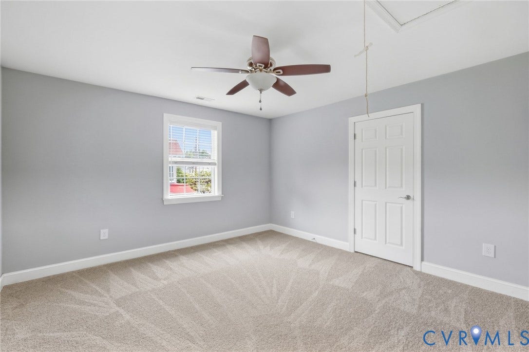 2002 Fairmount Avenue, Church Hill, Richmond, VA 23223 Carpeted flooring, white trim, a single window with blinds, a ceiling fan with light fixture, and a paneled interior door