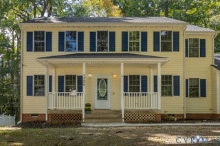 Two-story exterior with light-colored siding and dark shutters