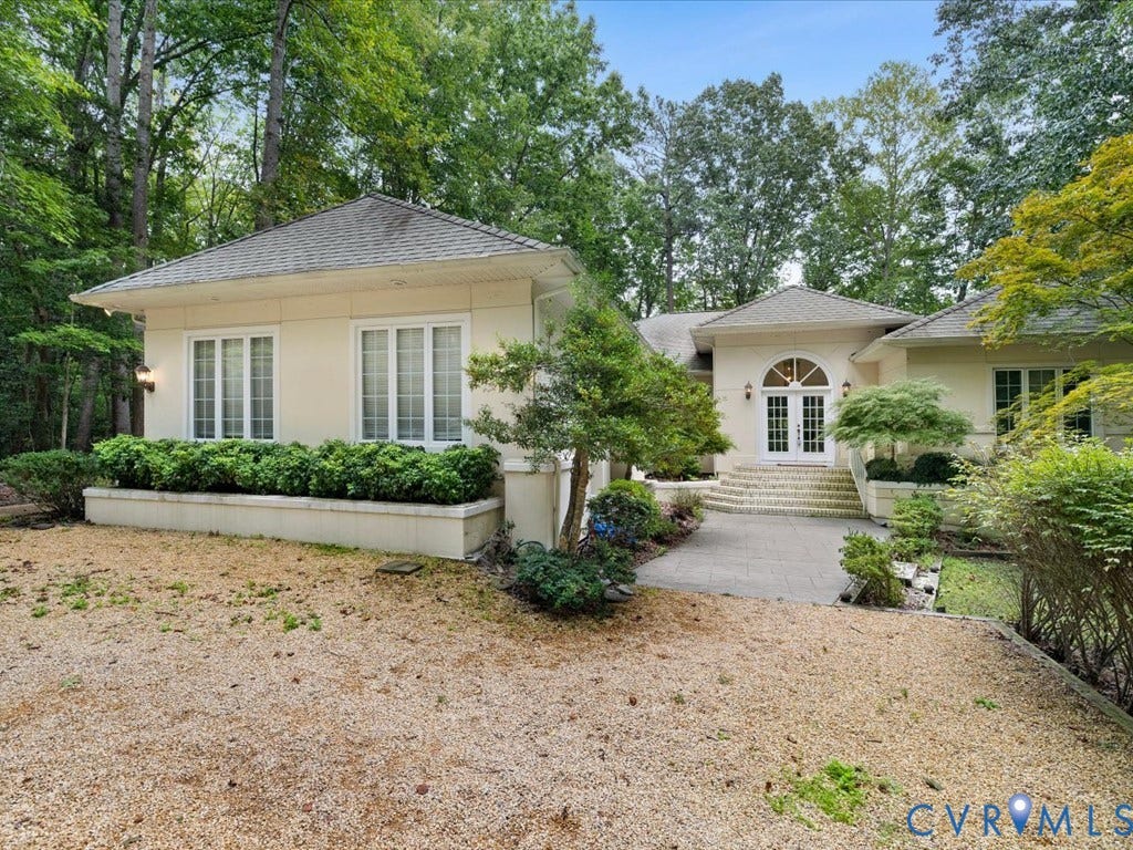 147 Oyster Cove Landing, Hartfield, VA 23071 Stucco exterior with a gabled roof, arched double entry doors, and a stone paver walkway