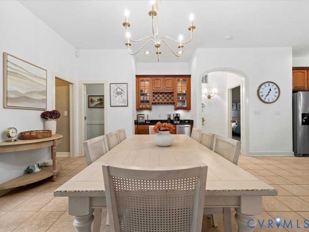 147 Oyster Cove Landing, Hartfield, VA 23071 Spacious dining area featuring a linear chandelier, tile flooring, and an arched doorway