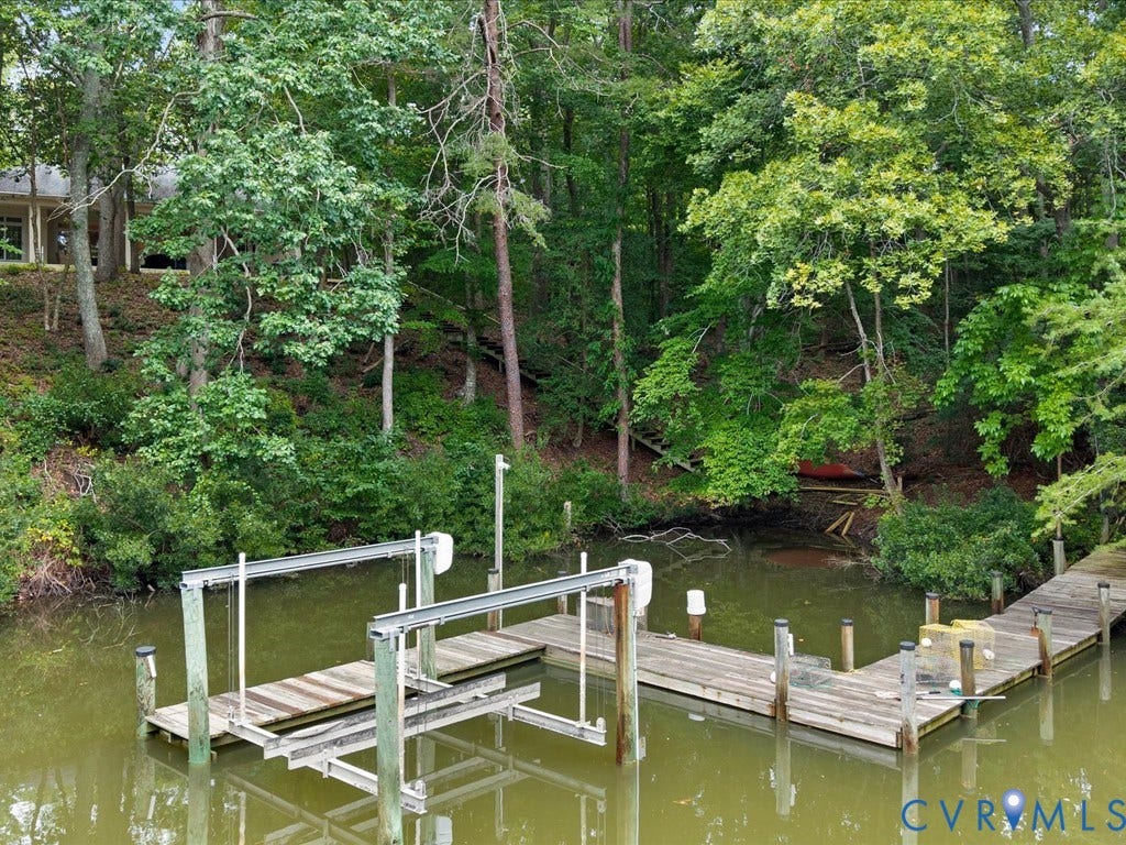 147 Oyster Cove Landing, Hartfield, VA 23071 Waterfront property featuring a private boat dock with an integrated lift system, and a wooded shoreline
