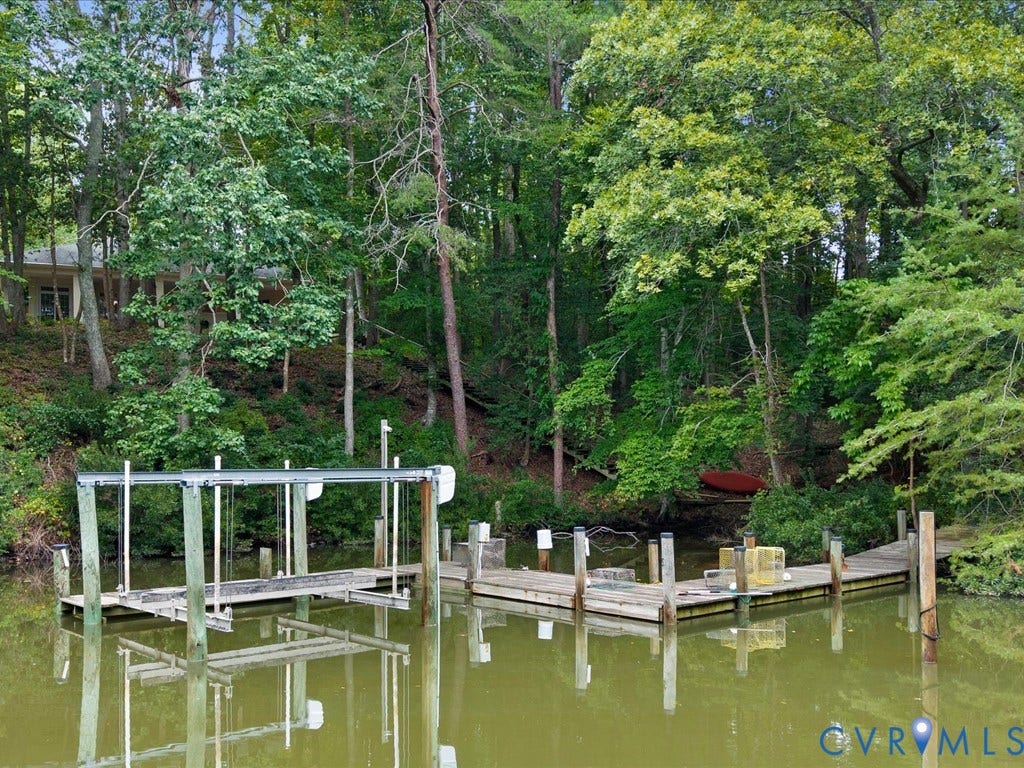 147 Oyster Cove Landing, Hartfield, VA 23071 Private dock with boat lift, featuring a separate pier and natural wooded surroundings