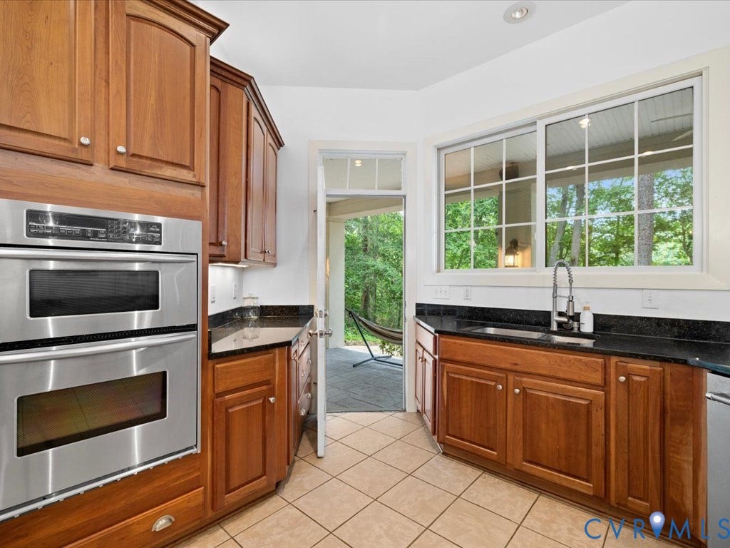 147 Oyster Cove Landing, Hartfield, VA 23071 Kitchen featuring wood cabinetry, stainless steel double wall oven, dark countertops, and a window above the sink