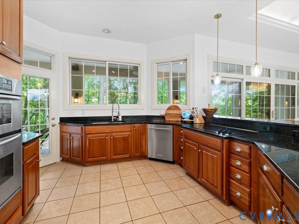 147 Oyster Cove Landing, Hartfield, VA 23071 Kitchen featuring wood-finish cabinetry, dark countertops, stainless steel appliances, and tiled flooring