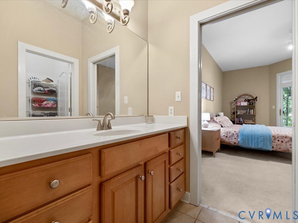 147 Oyster Cove Landing, Hartfield, VA 23071 Wood-finish vanity with a white countertop and undermount sink