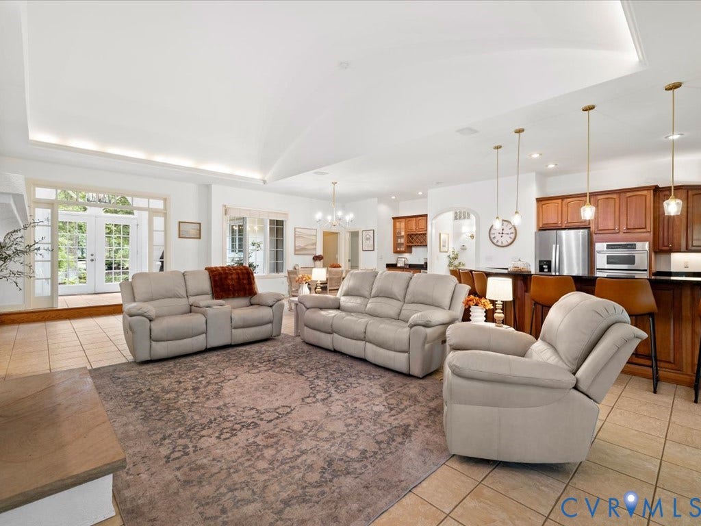 147 Oyster Cove Landing, Hartfield, VA 23071 Open-concept living space with tile flooring throughout, featuring a kitchen island with seating, pendant lighting, and stainless steel appliances