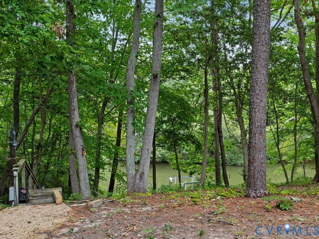 147 Oyster Cove Landing, Hartfield, VA 23071 Wooded property with a water feature, featuring a wooden stairway and a gravel path