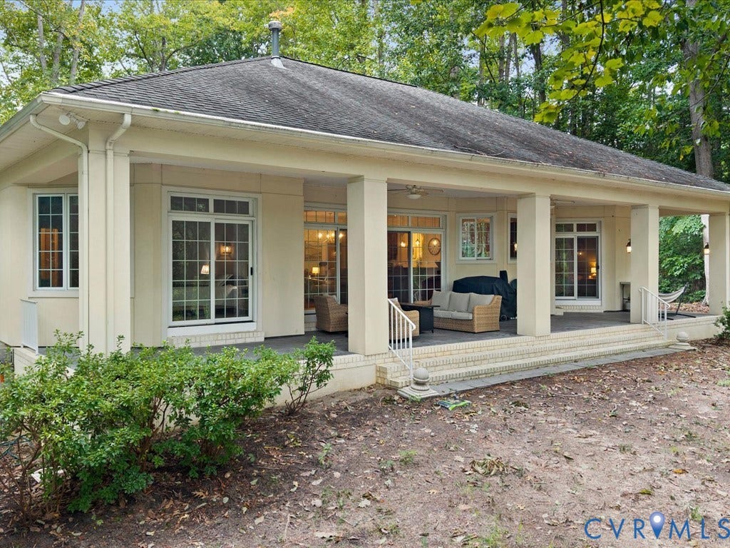 147 Oyster Cove Landing, Hartfield, VA 23071 Expansive covered patio with multiple sliding glass doors, white column supports, and a brick base