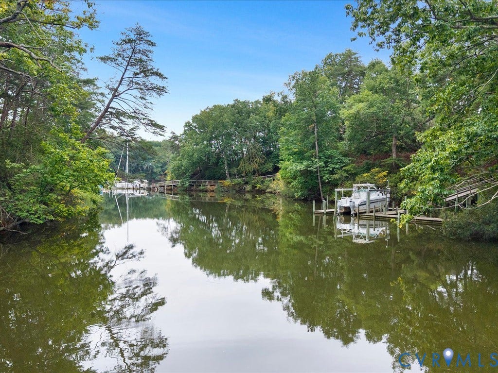 147 Oyster Cove Landing, Hartfield, VA 23071 Waterfront property featuring extensive natural foliage, private dock, and boat lift