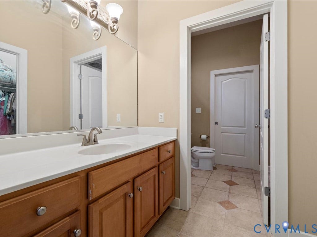147 Oyster Cove Landing, Hartfield, VA 23071 Wood-finish vanity with an integrated sink and brushed nickel faucet