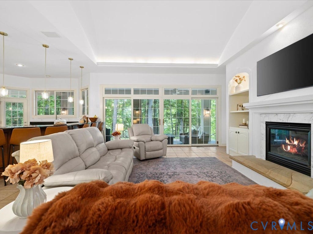 147 Oyster Cove Landing, Hartfield, VA 23071 Recessed lighting, wood-finish flooring, built-in shelving, white mantel fireplace, and glass sliding doors