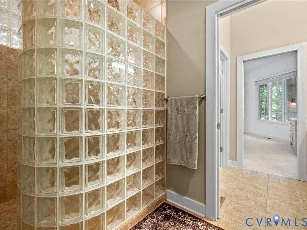 147 Oyster Cove Landing, Hartfield, VA 23071 Curved glass block shower enclosure, neutral tile flooring, and light-toned wall paint