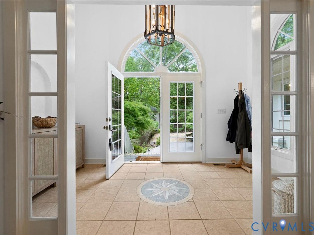 147 Oyster Cove Landing, Hartfield, VA 23071 Arched transom with double French doors, central compass rose tile inlay, light-colored square tile flooring, decorative chandelier, and sidelight windows