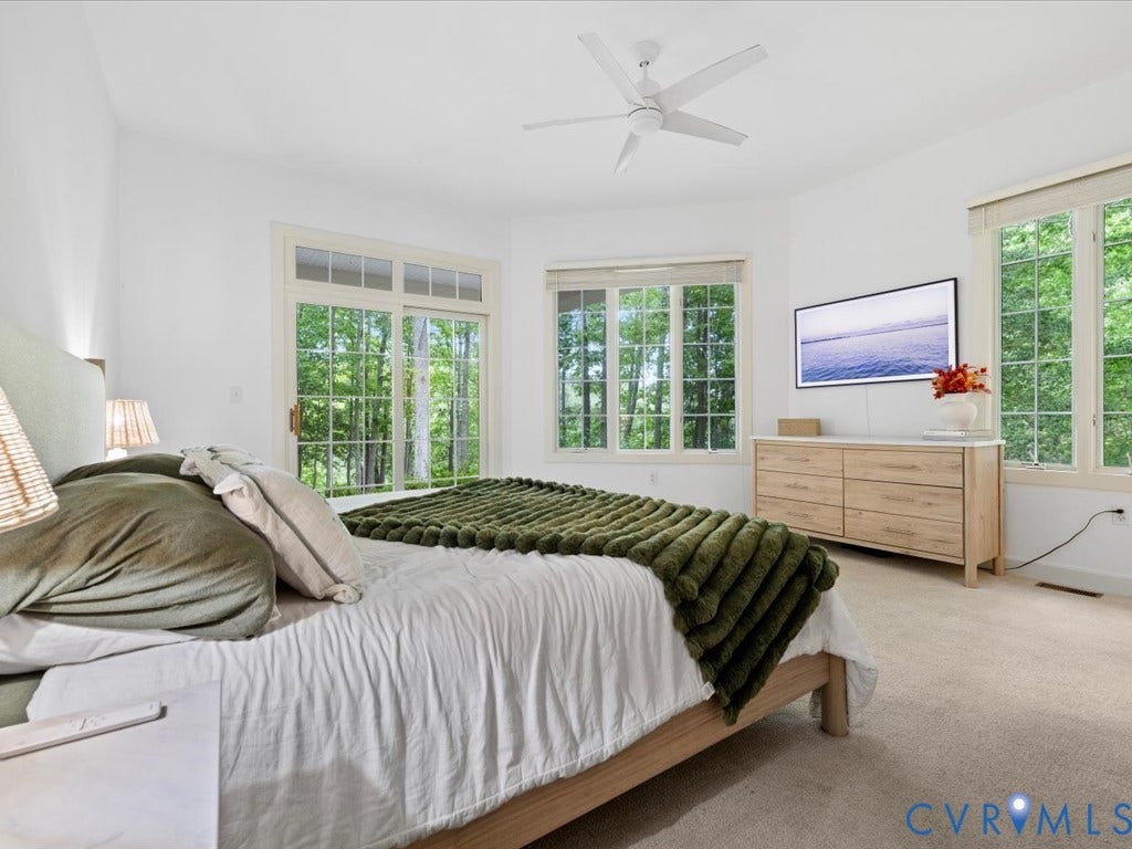 147 Oyster Cove Landing, Hartfield, VA 23071 Soft carpet flooring, white walls, large windows with natural light, and a ceiling fan