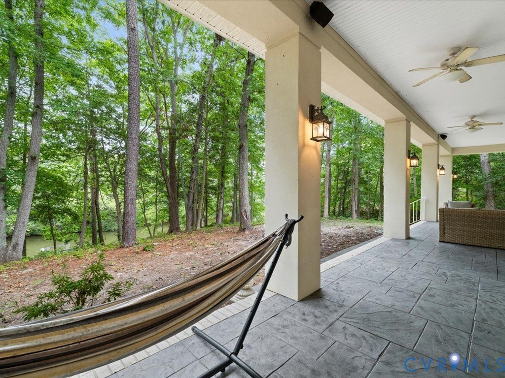 147 Oyster Cove Landing, Hartfield, VA 23071 Covered patio featuring an imprinted concrete surface, substantial support columns, and multiple ceiling fans