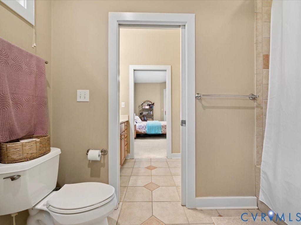 147 Oyster Cove Landing, Hartfield, VA 23071 Floor-mounted toilet, tiled flooring with contrasting inserts, white trim, and a tile-surround shower area