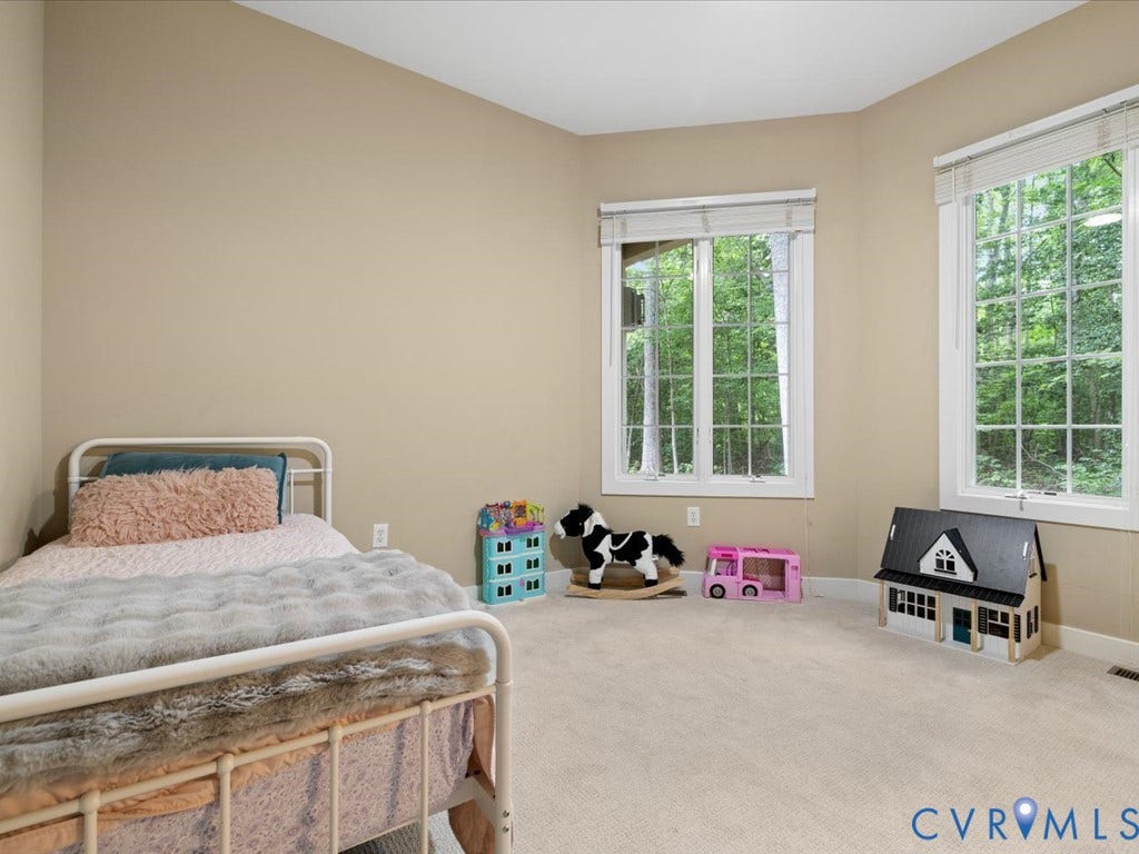 147 Oyster Cove Landing, Hartfield, VA 23071 Carpeted room with a vaulted ceiling, neutral wall tones, and two large windows with horizontal blinds