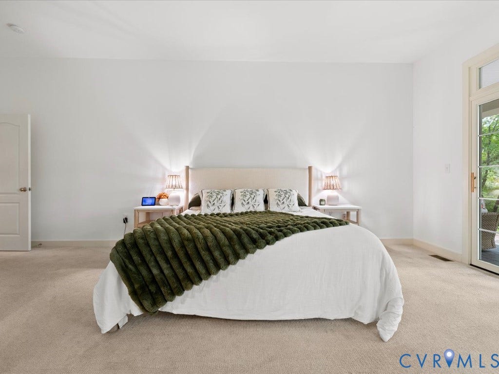 147 Oyster Cove Landing, Hartfield, VA 23071 Plush carpeting, a light-toned upholstered headboard, and dual bedside tables with integrated lighting