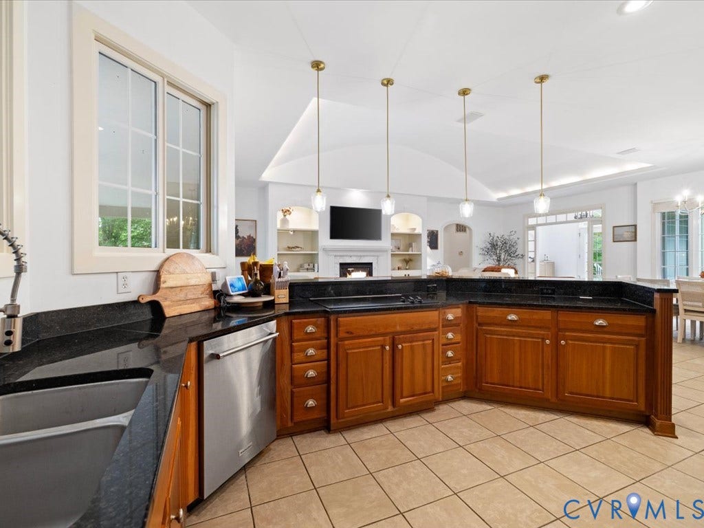 147 Oyster Cove Landing, Hartfield, VA 23071 Kitchen featuring L-shaped counter space with a built-in sink, stainless steel dishwasher, and dark countertops