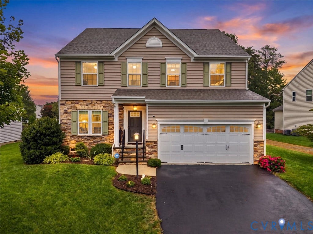 9990 Orchard Meadow Road, Mechanicsville, VA 23116 Two-story residence featuring a stone and siding facade, covered entry, attached two-car garage, and established landscaping