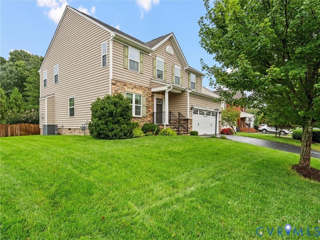 9990 Orchard Meadow Road, Mechanicsville, VA 23116 Two-story residence featuring siding and stone accents, an attached garage, and a covered front entry with railing