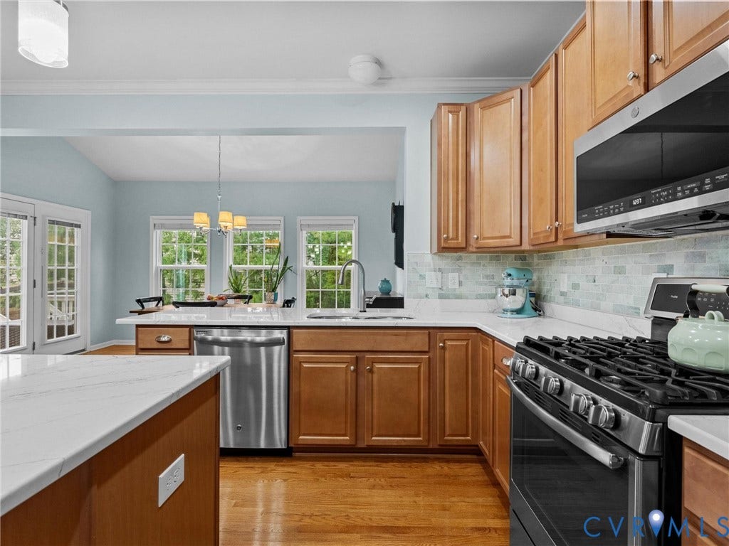9990 Orchard Meadow Road, Mechanicsville, VA 23116 Kitchen featuring wood-finish cabinetry, stainless steel appliances, white countertops, and a subway tile backsplash
