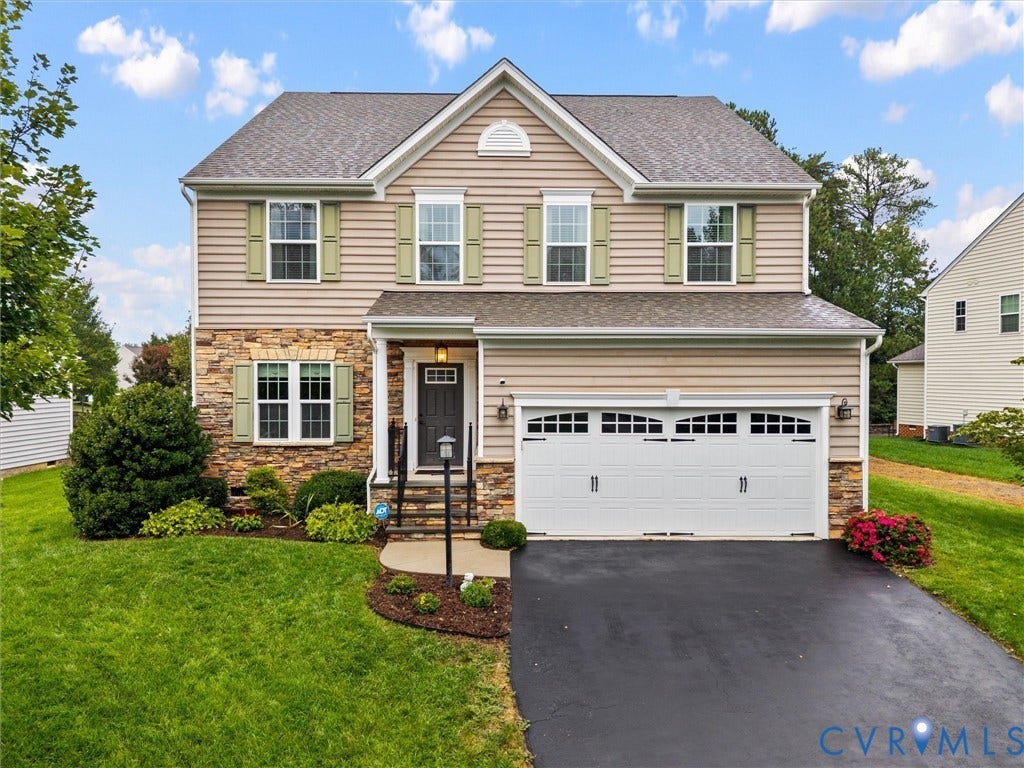 9990 Orchard Meadow Road, Mechanicsville, VA 23116 Two-story residence featuring stone and siding facade, double garage, front door with sidelights, and mature landscaping