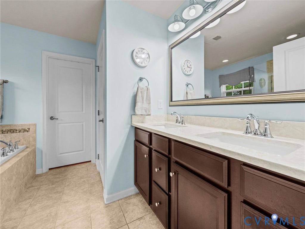 9990 Orchard Meadow Road, Mechanicsville, VA 23116 Double vanity with integrated sinks, chrome fixtures, dark wood-finish cabinetry, and a large framed mirror