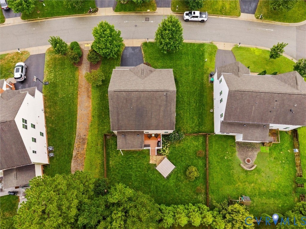 9990 Orchard Meadow Road, Mechanicsville, VA 23116 Expansive green spaces and mature trees surround the property, featuring a private fenced yard with a patio and an outdoor fire pit