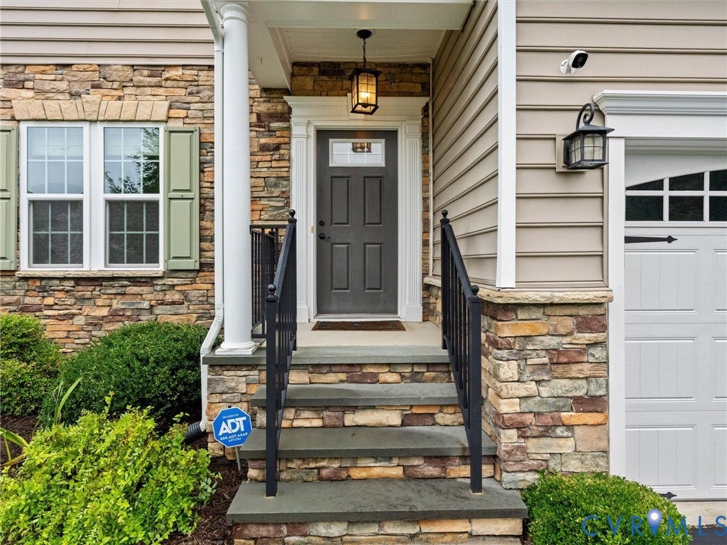 9990 Orchard Meadow Road, Mechanicsville, VA 23116 Entry with stone facade, decorative column, and dark gray paneled door with transom window