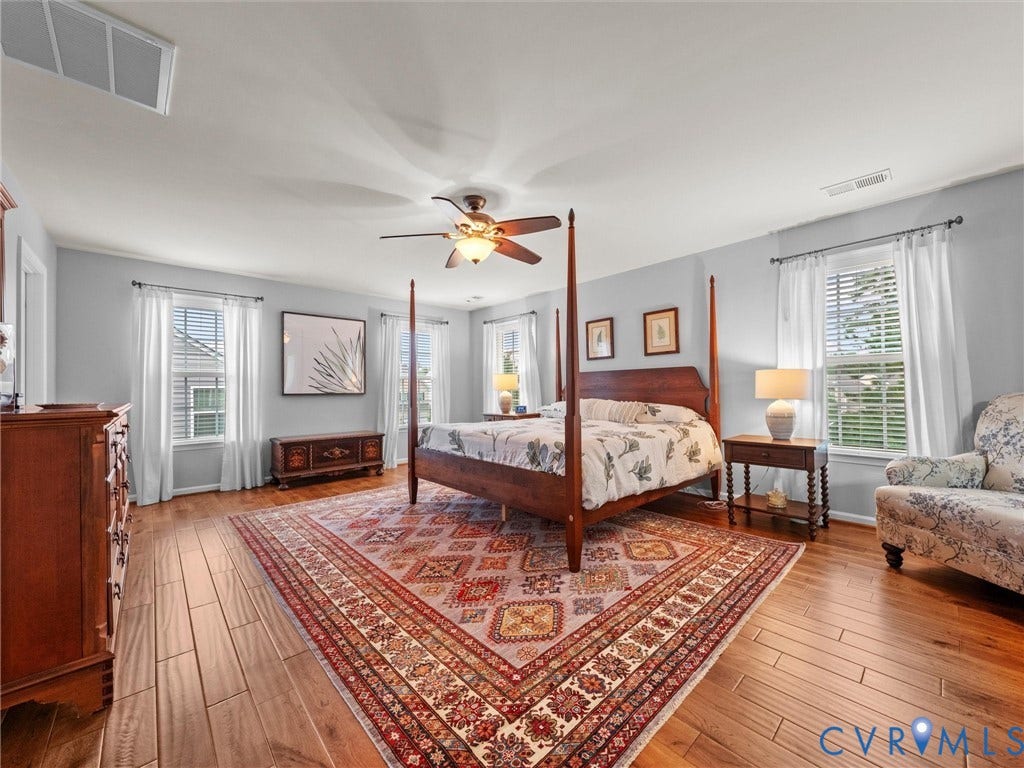 9990 Orchard Meadow Road, Mechanicsville, VA 23116 Spacious room featuring wood-finish flooring, light grey wall paint, and multiple windows with white blinds
