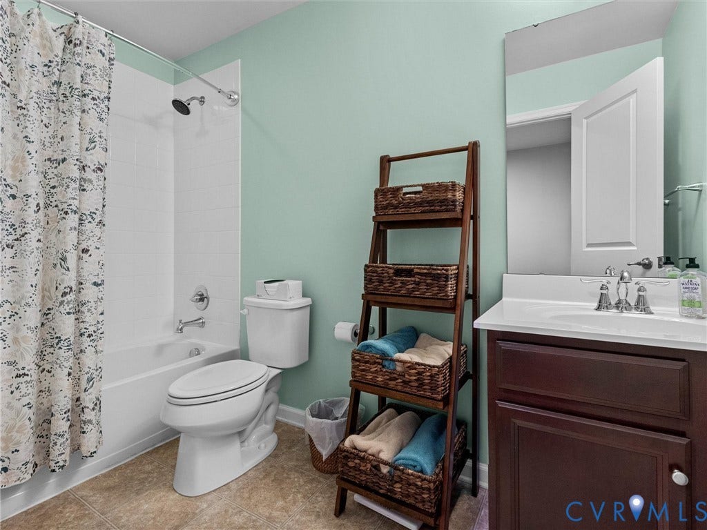 9990 Orchard Meadow Road, Mechanicsville, VA 23116 Tub/shower combination with white subway tile surround, white vanity with integrated sink, and chrome fixtures